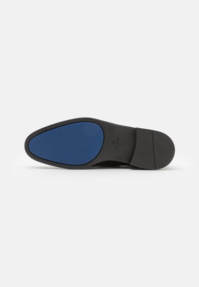 Black shoe sole with a smooth surface, featuring a blue rubber insert. Curved shape and textured elements near the heel.