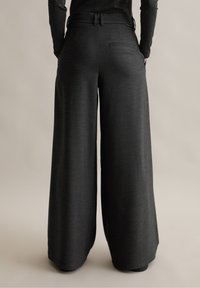 Wijdvallende broek in donker heather grijs stof, met een soepele textuur, ceintuurlussen en een enkele achterzak.