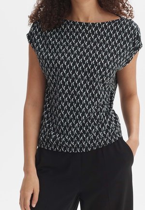 Schwarzes Oberteil mit weißem Halbmond-Muster, kurzen Ärmeln, rundem Ausschnitt und leicht gerafftem Design an der Taille. Leichter Stoff.