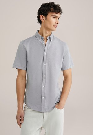Camisa de manga corta abotonada en tela gris claro, con un cuello casual, textura sutil y pequeño logotipo bordado en el pecho.