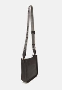 Borsa a tracolla nera in pelle con bordo superiore curvo e tracolla grigia regolabile con logo "MICHAEL KORS". Design elegante e minimale.