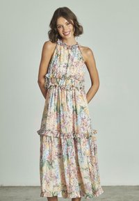 Abito maxi floreale in colori pastello con dettagli arricciati, vita elastica e scollatura a halter. Realizzato in tessuto leggero, scorre dolcemente.