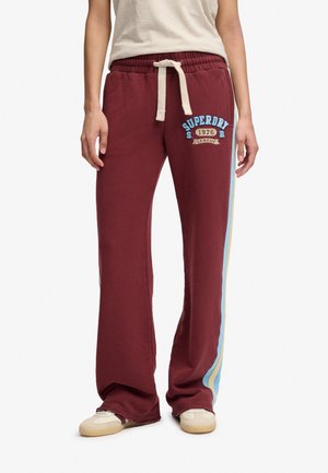 Bordowe szerokie dresowe spodnie z niebieskimi i beżowymi paskami po bokach, przednim sznurkiem i logo "Superdry 1976 League" na lewym udzie.