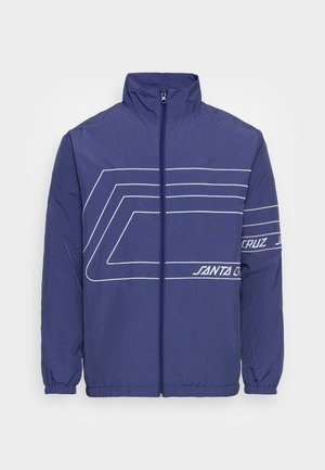 Navyblauer Windbreaker mit durchgehendem Reißverschluss, weißen geometrischen Streifen, elastischen Bündchen und "Santa Cruz"-Schriftzug auf Brust und Ärmel.