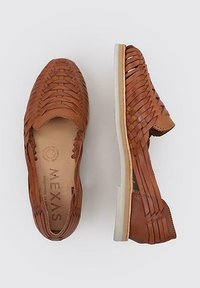Zapatos de cuero marrón tipo slip-on con diseño trenzado, puntera redonda y suela de goma ligera. Presentan una textura suave y detalles de costura mínimos.