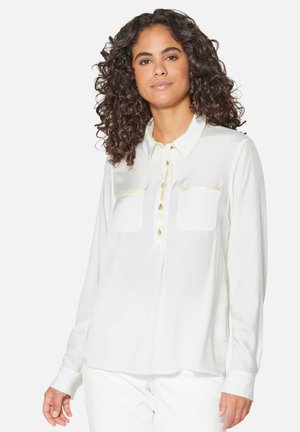 White long-sleeve shirt in lightweight fabric, featuring a button-down front, two chest pockets, and subtle gold accents. Smooth texture.