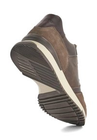 Brown leather and suede sneaker with a rubber sole featuring horizontal grooves and a cream-colored midsole. Elevated heel design.