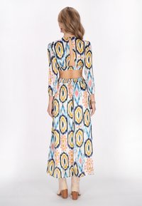 Rochie lungă cu un model abstract vibrant în nuanțe de albastru, galben și roz. Are o plată la spate și o talie ajustată, fabricată dintr-un material ușor.