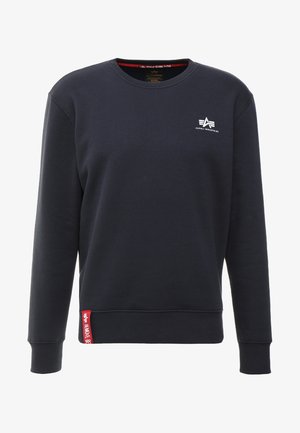 Navy sweatshirt made of soft material with a crew neck, ribbed cuffs and hem, featuring a white logo on the chest and a red label on the side.