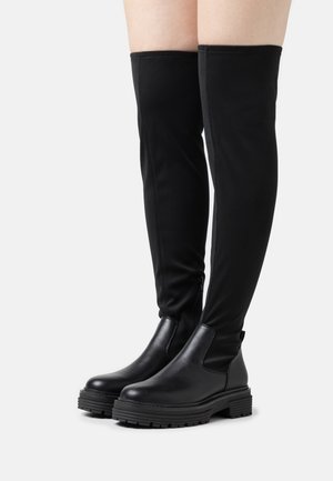 Zwarte over-de-knie laarzen met een glad leren neus en hiel, een rekbare stofschacht, dikke platformzool en een ritssluiting aan de zijkant.