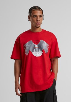 Rød bomulds T-shirt med et stort gråt ørnegraphic med udfoldede vinger og tre sorte stjerner ovenfor, afslappet pasform og rund halsudskæring.