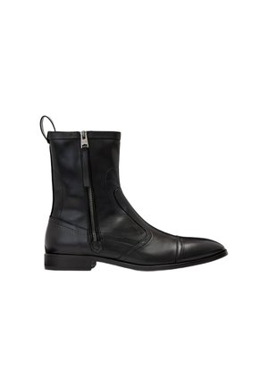 Bottine noire en cuir avec fermeture éclair latérale, bout rond, petit talon et languette à l'arrière.