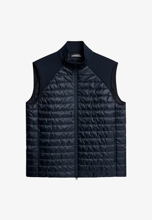 Granatowa pikowana kamizelka z wysokim kołnierzem, zamek błyskawiczny z przodu i kieszeniami po bokach. Posiada gładki, elastyczny materiał na ramionach i szyi.