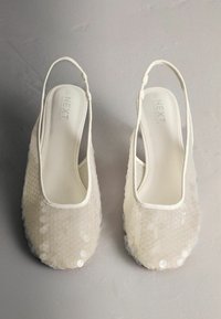 Baltos spalvos atverti batai su tekstūruotu viršumi, padengti blizgučiais. Apvalus noselis ir skaidri pado dalis. Skirti dėvėti oficialioms ar elegantiškoms progoms.