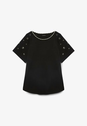 Schwarzes kurzärmeliges Oberteil mit silbernen Ösen an den Ärmeln und weißem, welligem Besatz am runden Ausschnitt.