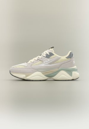 Fila sneaker in beige en lichtgrijs met mesh- en suède details, dikke zool en veters aan de voorkant, zijaanzicht op een neutrale achtergrond.