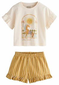 Kortærmet cremelivret t-shirt med et farverigt grafik og flæser, parret med gule stribede shorts med flæset kant.