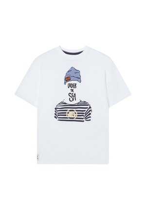 Camiseta blanca de algodón con un diseño de estilo cartoon que presenta un gorro azul y una camisa a rayas, con el texto "BAJO EL MAR" y un acento circular.