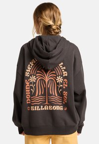 Czarna szara, oversize'owa bluza z kapturem z kieszenią kangurką, z pomarańczowym wzorem roślinnym i napisem na plecach. Materiał bawełniany z prążkowanymi mankietami.