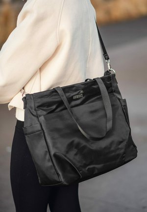 Schwarze Nylon-Shopper-Tasche mit zwei Griffen, Fronttaschen und einem eleganten Finish. Mit einem Logo auf der Vorderseite und verstellbarem Schultergurt.