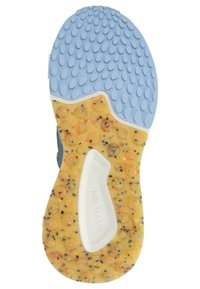 Schuhsohle mit einer strukturierten gelben Basis, die kreisförmige erhabene Muster aufweist, akzentuiert mit blauen und bunten Sprenkeln, beschriftet mit "KEIN NAME."