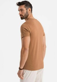 Brun kortærmet t-shirt lavet af blødt bomuld, med en afslappet pasform og rund halsudskæring, med en glat overflade og minimal dekoration.