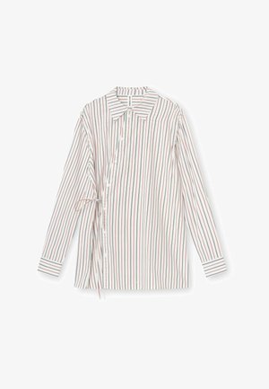 Valge triibuline pika varrukaga särk, millel on vertikaalsed punased ja mustad triibud, ees nööpidega ja ühel küljel reguleeritav lipsudetail.