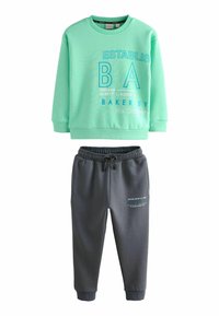 Mintgrön sweatshirt med blå bokstäver och grå joggers med elastisk midja. Mjuk, i bomullsblandning; avslappnad passform, lämplig för vardagsbruk.