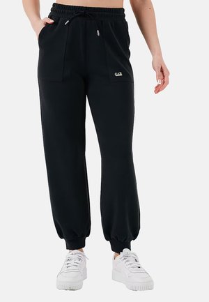 Pantaloni della tuta neri con vita elastica, cordino e due tasche anteriori. Fondo a costine e un piccolo logo sul taschino.