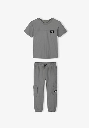 Grå kortærmet T-shirt med brystmærke og matchende grå cargobukser med elastisk talje og sidelommer med klapper.
