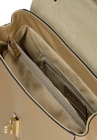 Beżowa skórzana torebka w środku z zamykaną kieszenią, fakturowaną podszewką oraz złotymi akcentami, charakteryzująca się gładkim wykończeniem i subtelnym przeszyciem.
