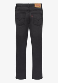 Jeans de mezclilla negra con un corte regular, pierna recta y dos bolsillos traseros, con una etiqueta de la marca visible en la cinturilla.