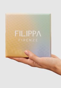 Square box with a textured gradient from yellow to light blue, featuring "FILIPPA FIRENZE" in bold white letters on the front.