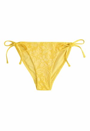 Gelbe Bikinihose mit floralem Strukturmuster und seitlichen Bindebändern an beiden Hüften, flach auf weißem Hintergrund liegend.