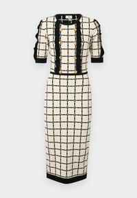 Rochie bej cu model în plasă neagră, cu mâneci scurte tip puff și detalii cu nasturi aurii. Are o siluetă ajustată și un design până la genunchi.