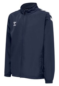 Marinblå vindjacka med dragkedja framtill, hög krage, elastiska ärmslut och vita chevronaccenter på axlarna.