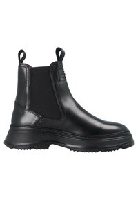 Botín Chelsea de cuero negro con paneles laterales elásticos y tiradores. Presenta una suela de goma gruesa con agarre texturizado y un sutil detalle de costura.