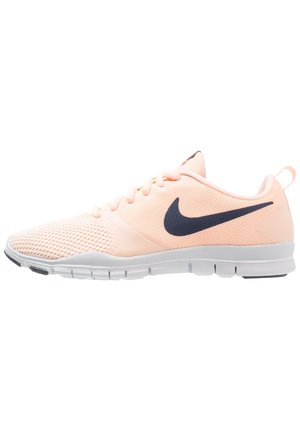 Chaussure de course Nike rose clair avec logo swoosh noir, semelle blanche flexible, dessus en mesh et lacets, vue de côté.