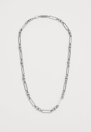 Sølvkjede med vekslende avlange og sirkulære lenker, med lås og liten logomerke på baksiden.