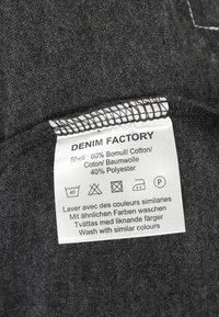 Etichetta in tessuto grigio con istruzioni di cura. Composizione del materiale: 60% cotone, 40% poliestere. L'etichetta presenta testo bianco e simboli di cura.