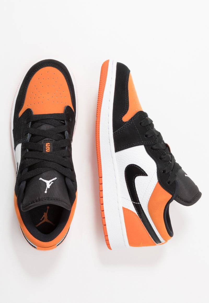 Sneaker basse con tomaia in suede nero e arancione e sintetico, dettagli in pelle bianca e suola in gomma texture.