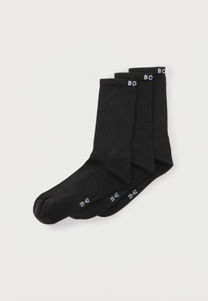 Drei Paar schwarze Sportsocken mit gerippten Bündchen und weißen Größenangaben "39-42" auf dem Fuß und "BO" am Bündchen.