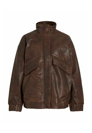 Giacca in pelle marrone con colletto alto, due grandi tasche con patta, polsini a costine e vestibilità rilassata. La pelle ha una finitura testurizzata.