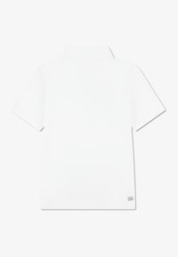 White short-sleeve polo shirt with a collar, made from lightweight material, featuring a small "ULTRA DRY" logo near the bottom hem.