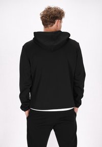 Zwart hoodie met lange mouwen, gemaakt van gladde stof. Heeft een relaxte pasvorm en een eenvoudig ontwerp zonder patronen of accenten.
