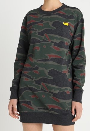 Robe sweat-shirt camouflage en vert foncé avec des accents rouges. Col rond, manches longues et coupe décontractée. Présente un petit logo jaune sur la poitrine.