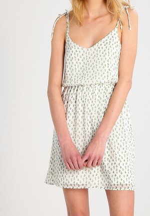 Vestito bianco con stampa di cactus verdi, spalline sottili e vita aderente. Tessuto leggero con silhouette ampia e fluida.