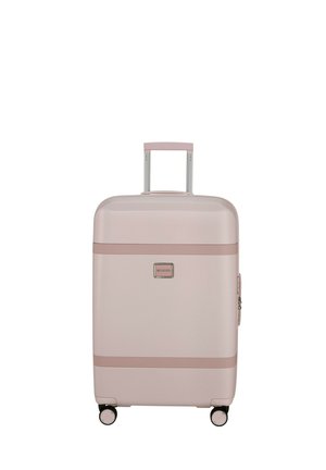 Hard-shell luggage in light pink with a smooth texture, rose gold accents, two wheels, and a retractable handle.