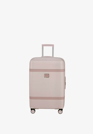 Hard-shell luggage in light pink with a smooth texture, rose gold accents, two wheels, and a retractable handle.