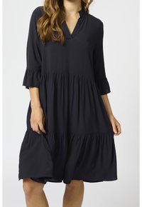 Schwarzes, knielanges Kleid mit einem gestuften Design, dreiviertellangen Ärmeln mit Rüschensaum und einem V-Ausschnitt. Glatte Stofftextur.